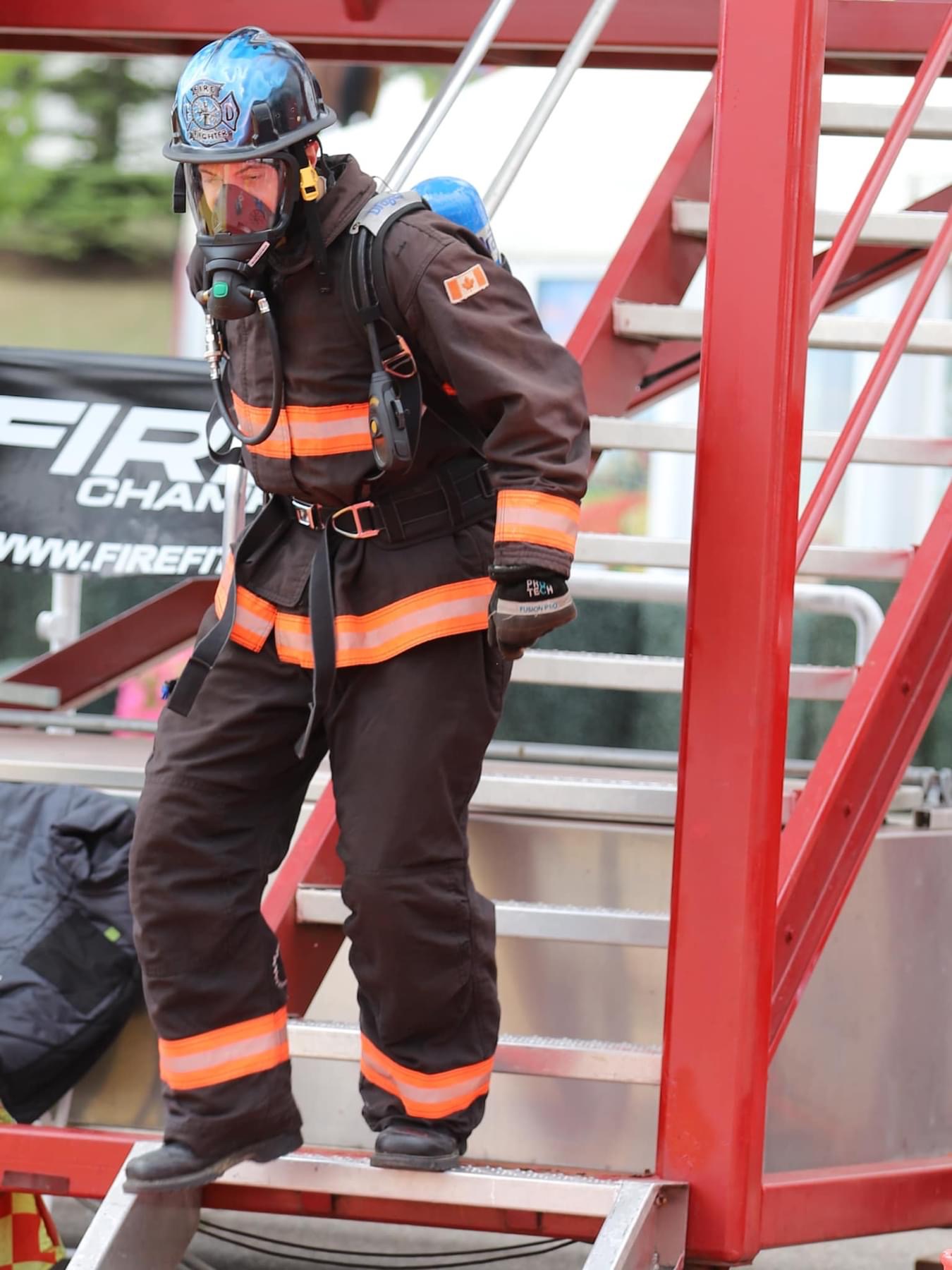 Firefighter climbing stairs in full gear during competition